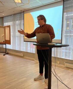 Gaute Skjervø står foran lerettet og holder innlegg.